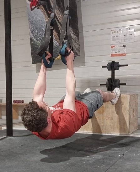 Traction horizontale sur TRX : position basse, corps gainé proche de l'horizontale, bras tendus