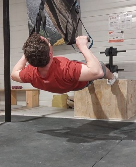 Traction horizontale sur TRX : position haute, coudes amenés à hauteur des épaules
